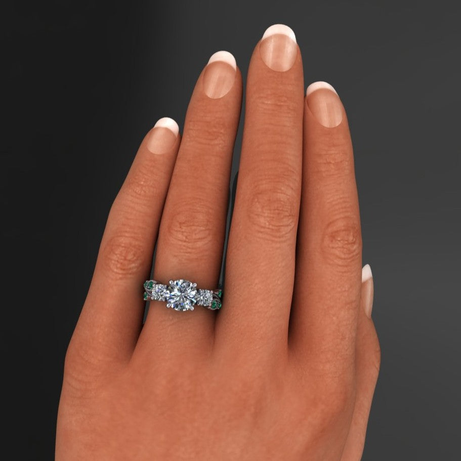 1.5 carat round three stone ring with green moissanite accent stones - hand model