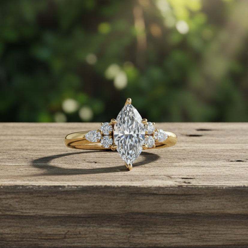 A yellow gold ring featuring a large marquise-cut diamond center stone with smaller round and marquise diamonds on the shoulders, shown on a reflective dark gray background.