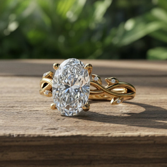2 carat oval lab created diamond ring with leaf details on a wooden table. 
