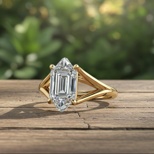 Gold ring with a large diamond on a rustic wooden table, with lush greenery in the background