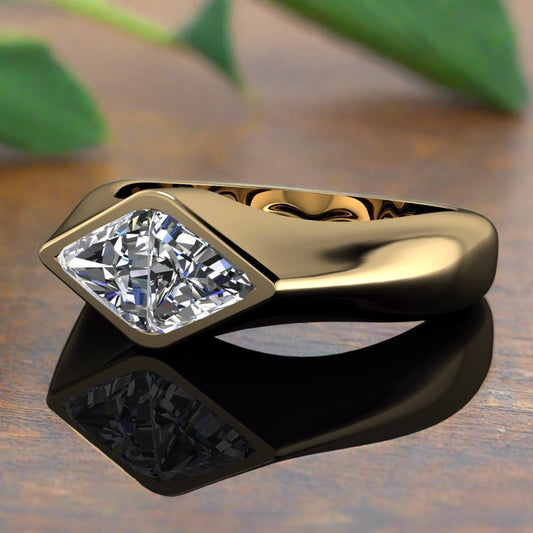 lozenge or kite shaped lab grown diamond bezel engagement ring - laying on a wood table