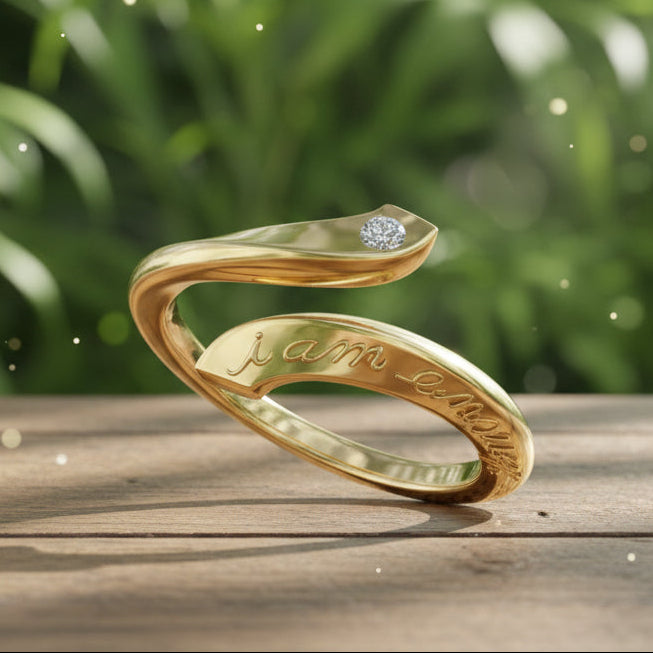 Gold ring with diamond and 'i am enough' engraving on a black background