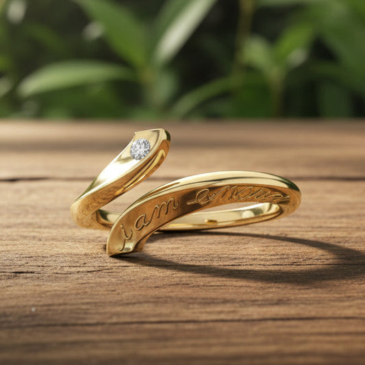 Gold ring with diamond and 'I am enough' engraving on a reflective surface