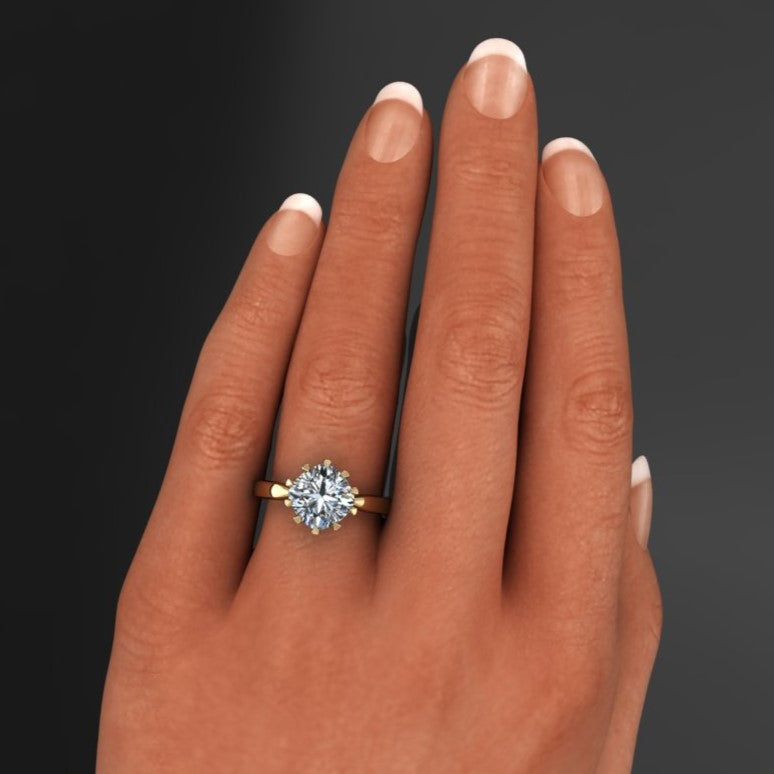 The Lady Danbury ring featuring a 2.5 carat old mine cut cushion moissanite center. A solitaire ring with 10 prongs, hand model