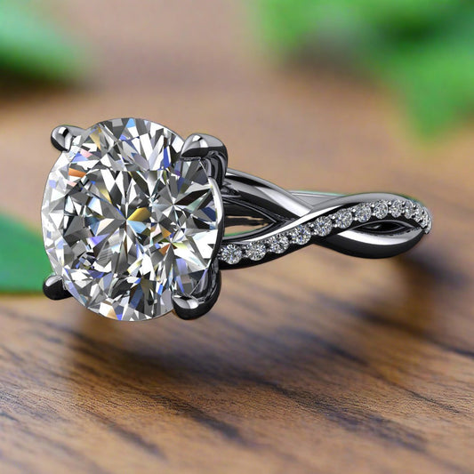 Neri ring - 3 carat round lab grown diamond engagement ring, with a twisted infinity style band, set with small diamonds - laying on a wood table with leaves in the background