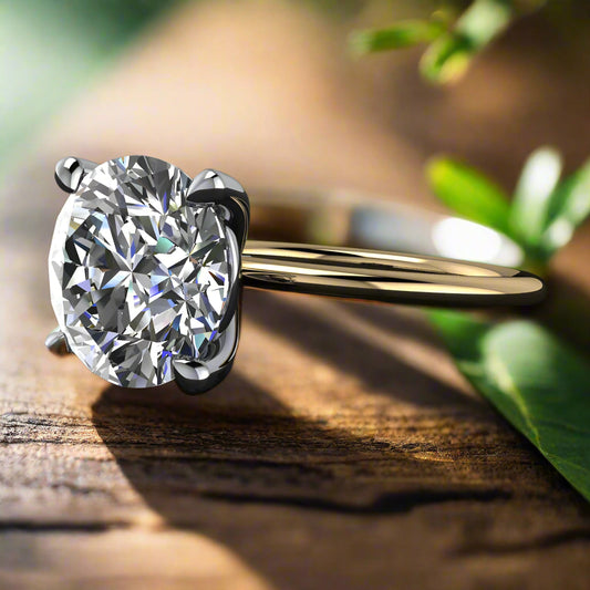 naked shay - 3 carat round lab created diamond ring - laying down on a table with green leaves in the background