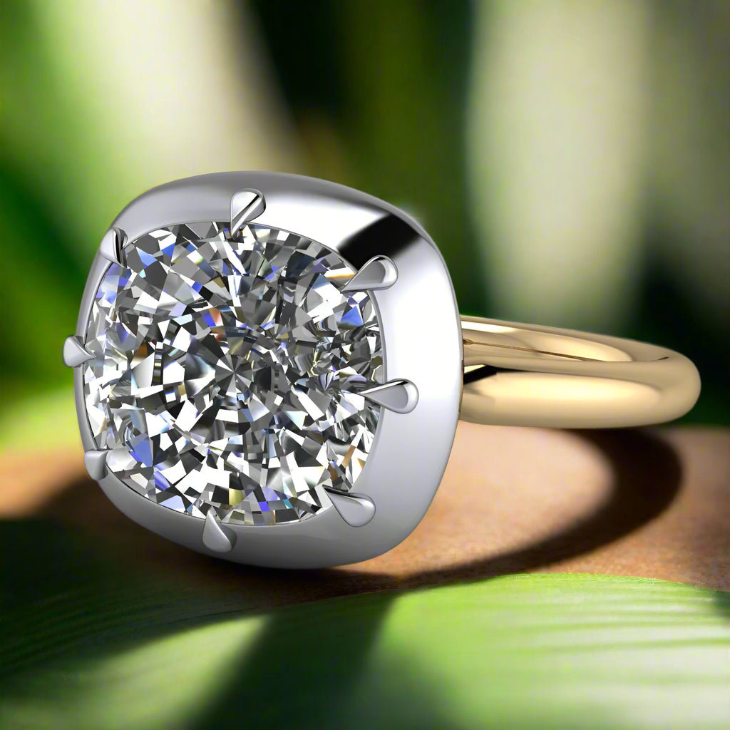 zendaya ring - 3 carat east west cushion engagement ring - laying down on a wood table with green leaves
