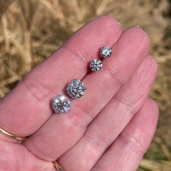 video of size comparison between larger and smaller stud earrings 